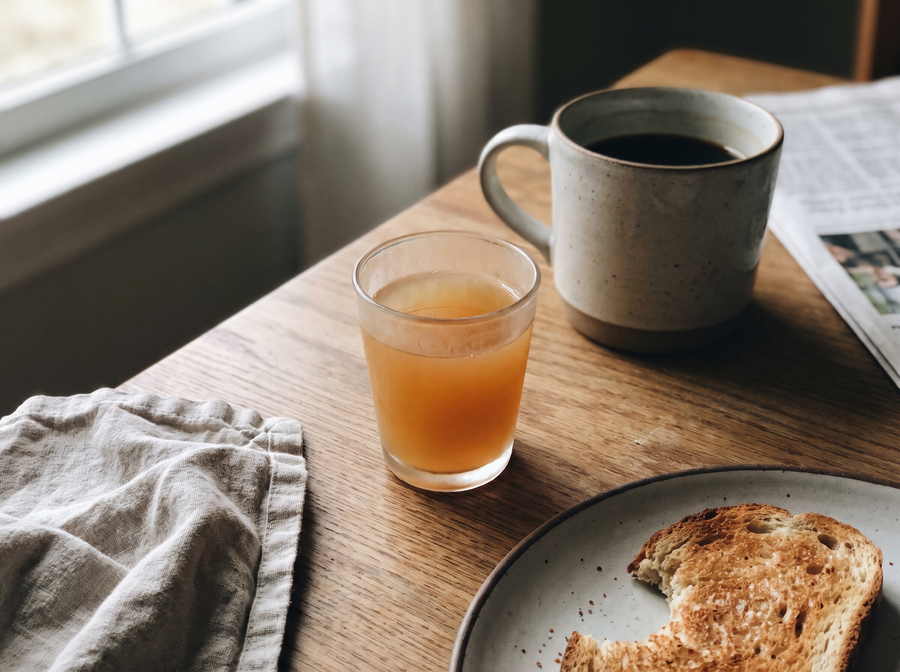 Schnapsglas mit Apfelessig auf Frühstückstisch
